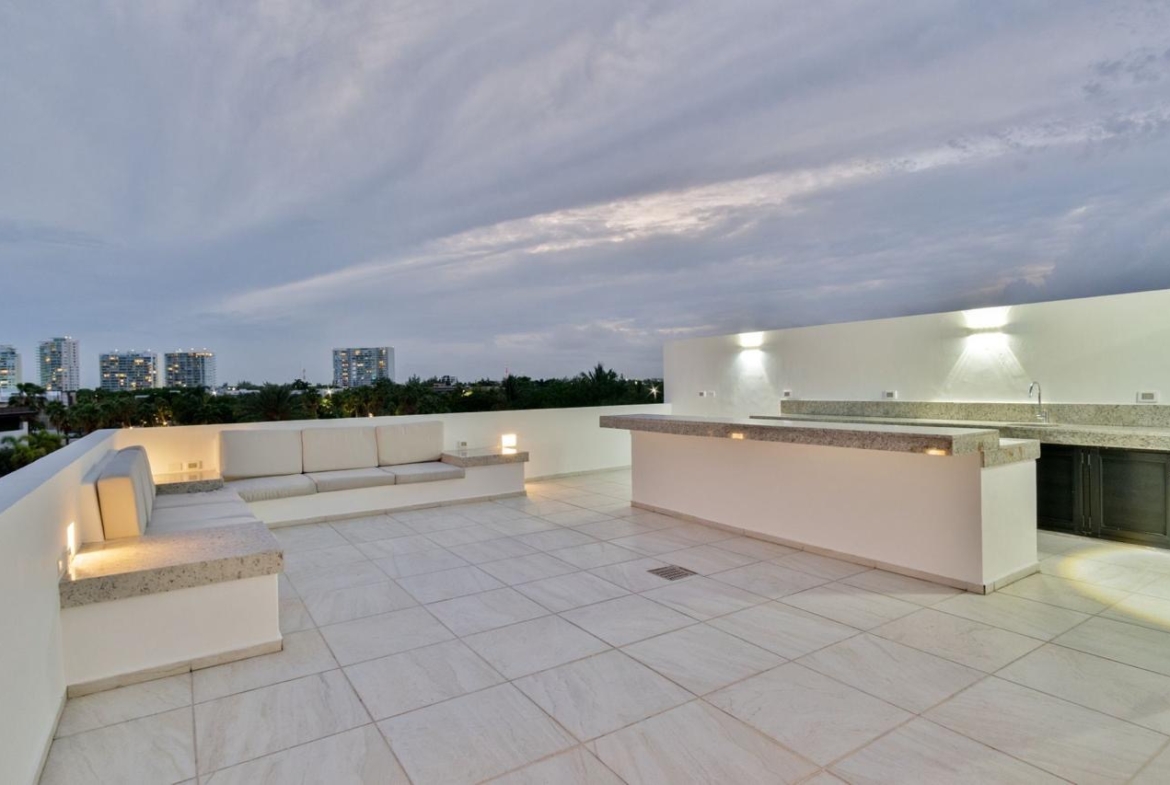 Vista del roof con barra de granito de una casa de lujo en venta en Puerto Cancún, con diseño moderno, increible iluminación y diseños de lujo.
