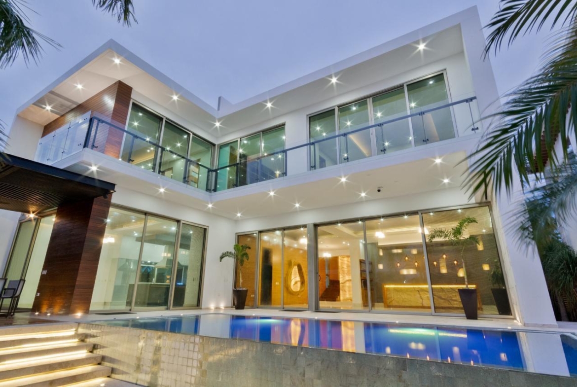 Fachada de la terraza con alberca de una casa de lujo en venta en Puerto Cancún, con diseño moderno, increible iluminación y diseños de lujo.