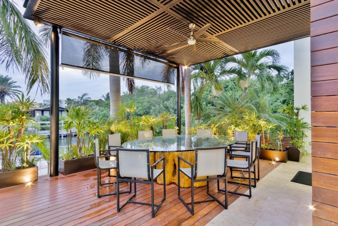 Vista de la terraza con comedor de una casa de lujo en venta en Puerto Cancún, con diseño moderno, increible iluminación y diseños de lujo.