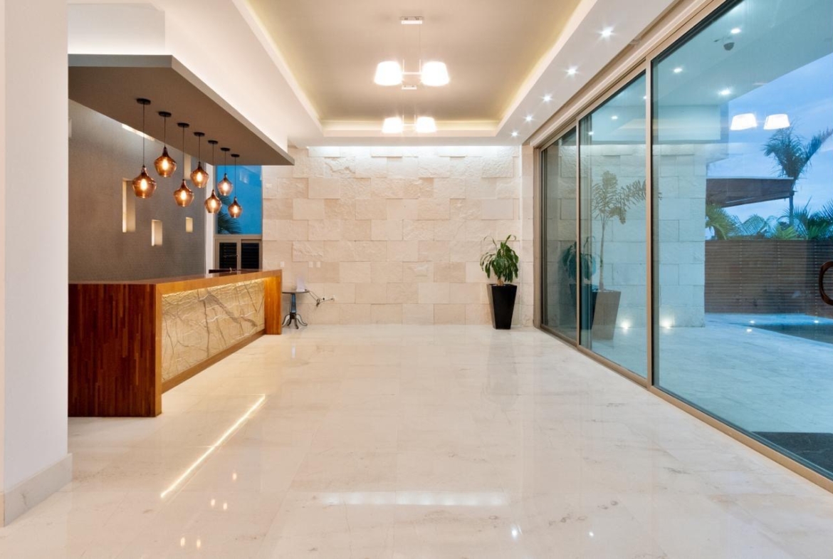 Área social con barra, cava e invreible vista a la terraza con elbarca, de una casa de lujo en venta en Puerto Cancún, con diseño moderno, increible iluminación y diseños de lujo.