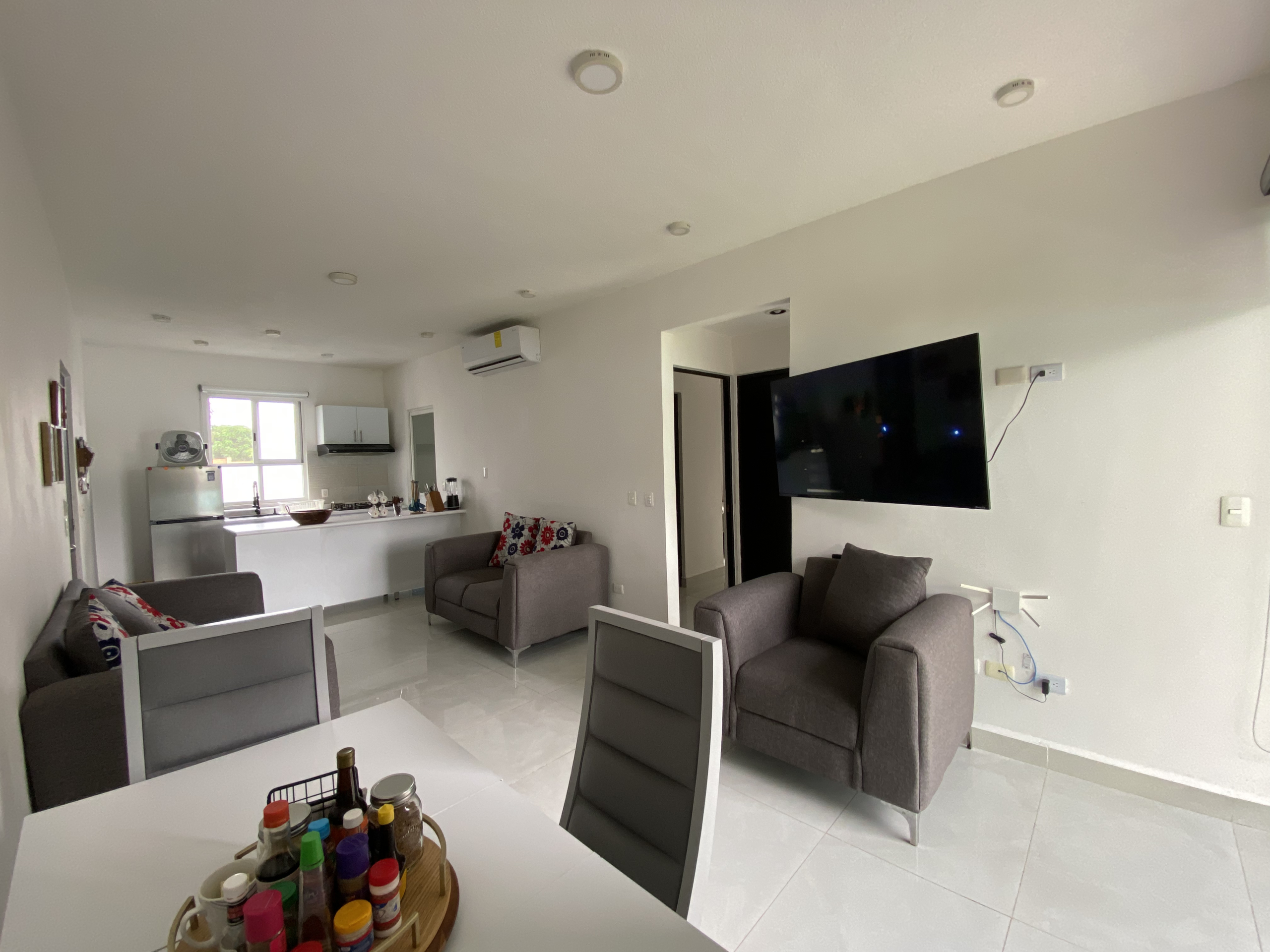 Sala, comedor y cocina integral de un departamento en venta en Dream Lagoons Cancún